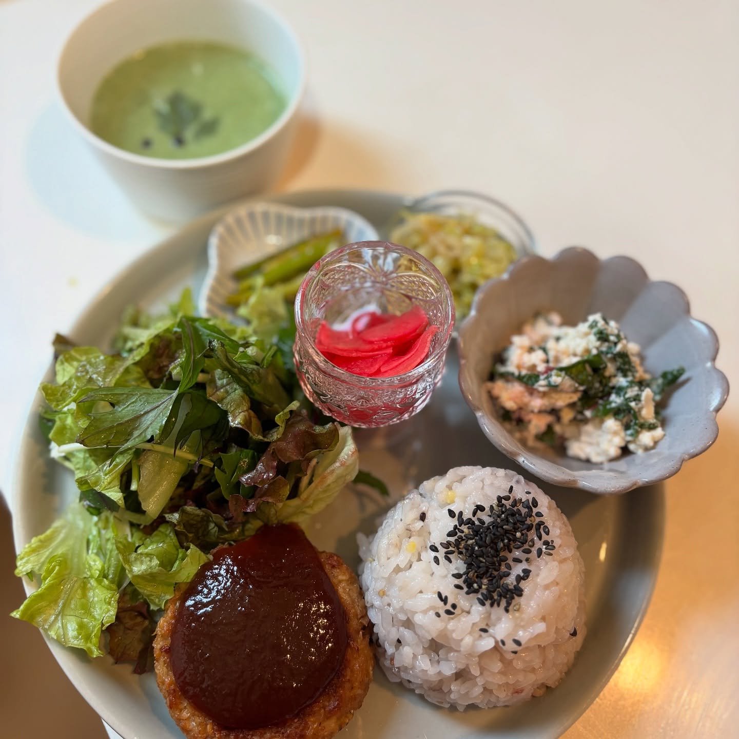 今週のプレートメインは大豆ミートハンバーグです。徳島県の美味フーズさんの濃厚トマトケチャップを使ったオリジナルソースをかけて。今は葉物が豊富でレタスや水菜がとても美味しいです。サニーレタス、水菜、赤水菜、わさび菜、カブやラディッシュをゆずのドレッシングでまとめた旬のサラダもおすすめです。スープは春菊のポタージュ(スープの詳細はスープアカウントで @hanoens.soup )今週のセットデザートはスパイスキャロット洋酒のショコラケーキハイビスカスのクリームケーキ豆腐のコーヒー生チョコフロランタンタルト苺のミルフィーユパイナップルケーキ(金曜から)ランチのミニデザートは2個でもセットにできます。今日は比較的静かです。どうぞよろしくお願い致します。