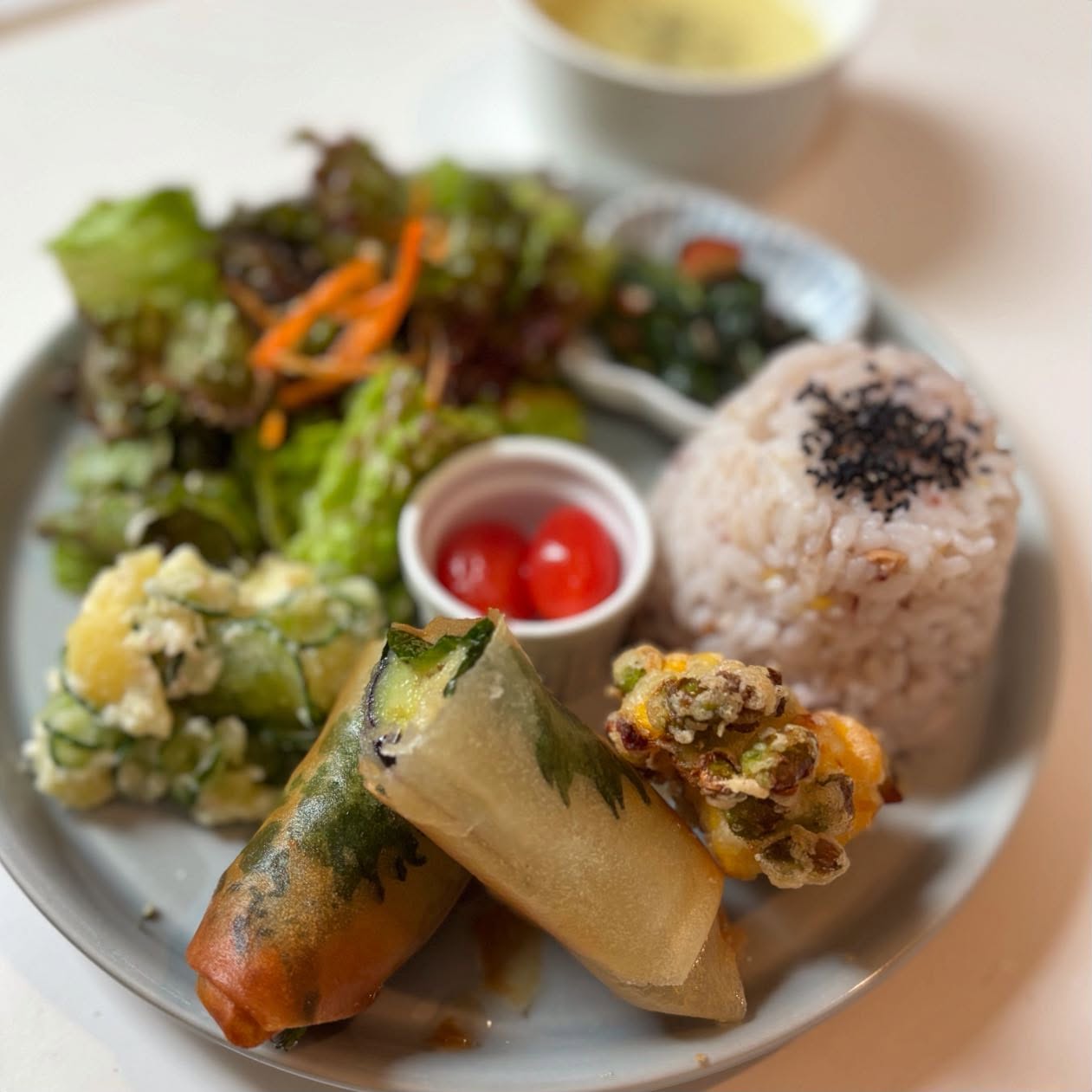 🥢今週のプレートメインは夏のナスと青紫蘇のヴィーガンチーズ春巻きです。サクッとパリッと、そして中はジューシーなナスが楽しめます。今週は枝豆やとうもろこし、きゅうりなど夏野菜をたくさんお惣菜に含めました。枝豆ととうもろこしのフリットは上質のお塩だけで召し上がっていただきます。ジメジメした季節ですが、梅ソーダやハイビスカスなどのドリンクとともに夏野菜などで体力を維持しましょう〜。今週もよろしくお願い致します