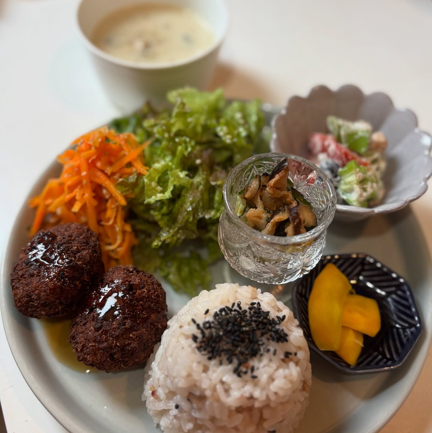 🥢今週のプレートは、大豆ミートボール甘酢あんがけです。お惣菜になすときゅうりの柴漬け風を添えました。スープは4種のキノコのクリームスープ。爽やかなヒハツパウダーを加えて炒めたきのこに米粉を加えてグルテンフリーのスープに。ヒハツは長胡椒(ロングペッパー)といわれるスパイスで、黒胡椒より爽やかで柔らかい印象です。気管支や喘息の諸症状にもよく用いられるとアーユルヴェーダの本でも紹介されています。特に夏の暑い時期の消化機能が落ちているときにはお勧めのスパイスですキッシュは紫芋の甘煮キッシュフォカッチャはローズマリーと粒マスタードポテトデザートは桃パフェ桃タルト桃ゼリーキャロットケーキ生チョコなどご用意しています。今週もよろしくお願い致します