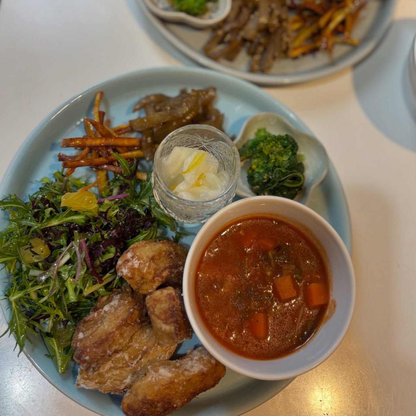 🥢今週のプレート車ふスパイシータツタ水菜と八朔のサラダ菜の花の胡麻和えさつまいものスティック揚げヤーコンきんぴら冬野菜のトマトスープ雑穀ごはん水菜のサラダは自家製八朔ドレッシングもおすすめです今週もよろしくお願い致します